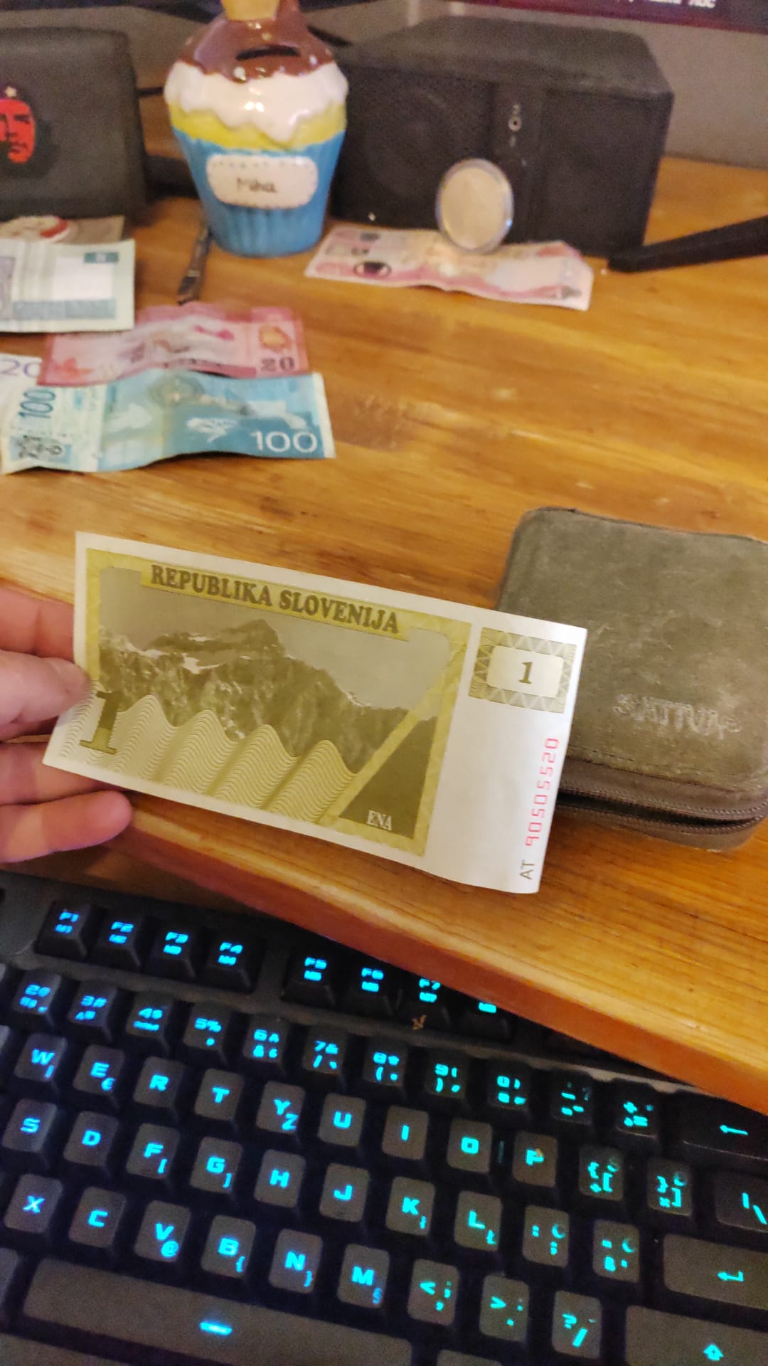 A hand holding a 1 Lipa Republika Slovenija provisional banknote featuring Mount Triglav — Slovenia's first paper money issued in 1990 before the Tolar.